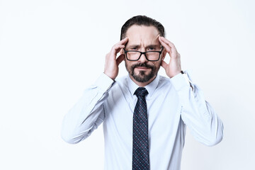 A man in a shirt holds on to his sore head.