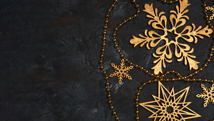 Christmas or New Year dark wooden background, Xmas black board framed with season decorations, space for a text. Christmas Background - Gold Snowflakes On dark background. Golden snowflakes. 