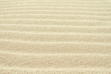 Fototapeta na wymiar Rippled sand on the sea coast formed by wind and water, background, texture, pattern
