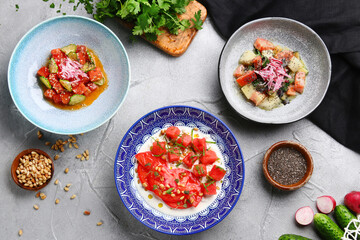 stracciatella salad with tomatoes and watermalone and ingredients on light concrete table top view