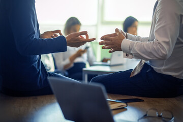 Business meeting of partners. Close up shot of human hands gesturing during discussion in foreground. Office workers works on blurred background. High quality photo