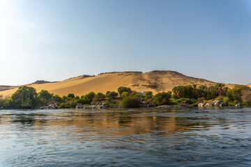 Fototapeta na wymiar Small towns and ancient temples navigating the Nile River in Aswan city. Egypt