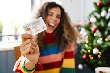 Excited charming woman screaming and showing credit card