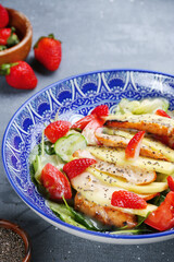 salad with chicken and strawberry, mango and chia seed top view. salad with meat and fruits on concrete table
