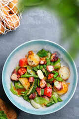 potatoes and octopus salad with ingredients on table top view