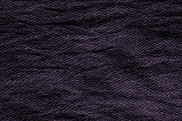 Blank surface of rough, crumpled burlap. Abstract background of dark color from a textile material.