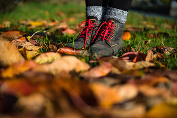 Woman in hiking boots Standing in autumn leaves background