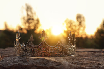 mysterious and magical photo of silver king crown in the England woods over stone. Medieval period...