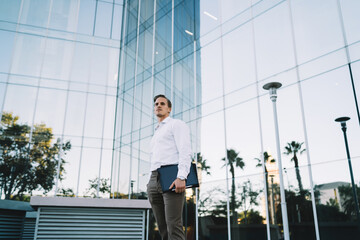 Confident businessman with tablet standing in downtown