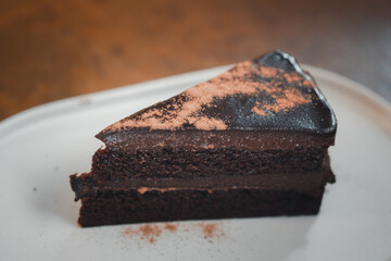 Slice of delicious chocolate cake on desk