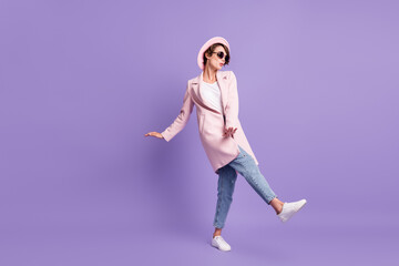 Full size photo of dancing nice cool girl look empty space sing wear glasses coat cap jeans footwear isolated on purple background