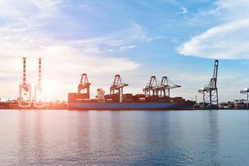 Ship in port, Cargo Container ship mooring alongside in port with bridge crane in export, import and logistics business on twilight .