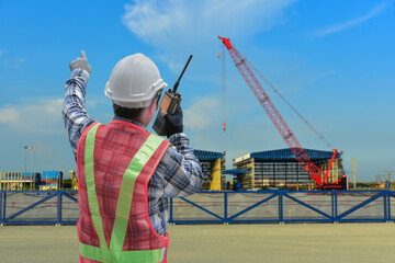 Industrial, building, technology and people concept close up of male builder in hardhat with walkie talkie or radio outdoor in construction site.