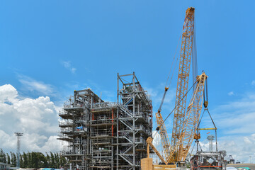 Fototapeta na wymiar Construction site, Structure platform, power plants and Oil refineries during big crane loading productions in site.