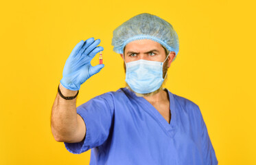 medical specialist hold test tube, selective focus. doctor wear respirator mask. nurse with...