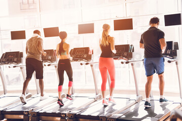Obraz na płótnie Canvas People athletes on treadmills run together