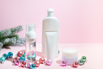 Obraz na płótnie Canvas Christmas beauty skin care cosmetic products with decoration balls on the pink background