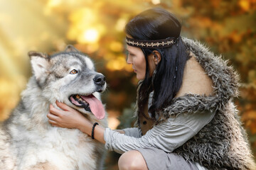 Woman with an Alaskan Malamute dog in the autumn forest