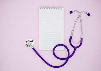 Stethoscope, Notepad on a pink background with copy space. Medical flat lay.