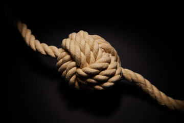 Concept Shot Of Rope Tied With Knot On Black Background To Illustrate Problem Or Mental Health Issue