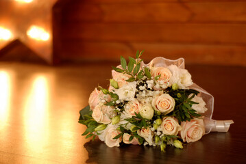 Bride's wedding bouquet lies on the wooden floor