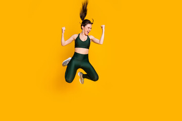 Full size photo of nice excited lady jump high up succeed slimming wear sports suit shoes isolated yellow color background