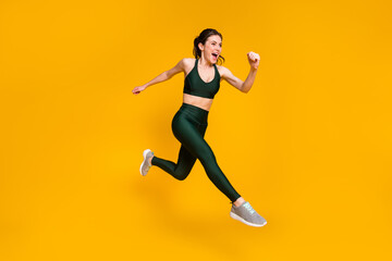 Fototapeta na wymiar Cheerful lady jump high jogging marathon speed race competitive person wear sports suit shoes isolated yellow color background