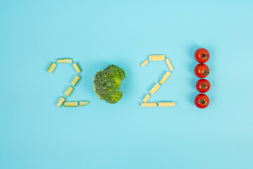 Obraz premium 2021 Happy New Year and New You with vegetable; Cucumbers, baby corn, Cherry Tomatoes and Broccoli arrangement on blue background. Goals, Healthy, Resolution, Time to New Start and dieting concept