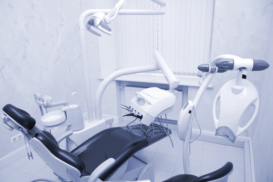 Modern dental office. Dental chair and other accessories used by dentists in blue, medic light