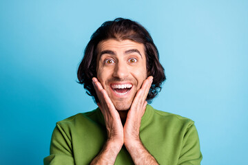 Close up photo of astonished person arms on chin open mouth green pullover isolated on blue color background