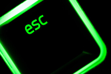 Green illuminated keyboard esc escape key closeup