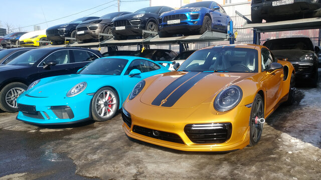 Moscow, Russia - May 09, 2019: Golden Porsche 911 Exclusive series. Limited edition. Number three hundred thirty seven. In the world were produced only 500 cars. Near parked blue 911 GT3 RS