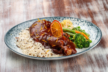 Duck in orange sauce with blanched vegetables and rice