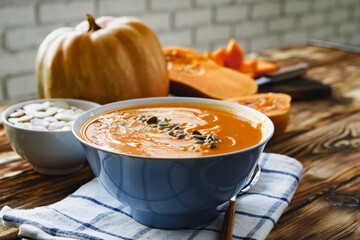 Creamy pumpkin soup on a wooden table