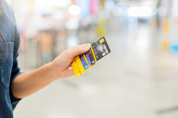 Close up woman hand with many credit card and Blurred shopping mall on background.