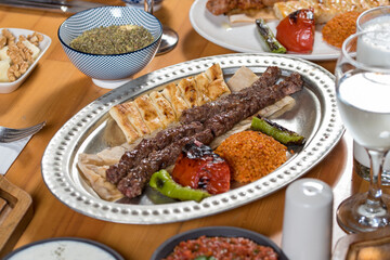 shish meatball kebab from turkish cuisine. served with white plate on wooden table.