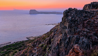 Sunset view of Gramvousa islet behind the rocky hills of Balos beach area, Crete, Greece.