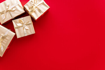 Red Christmas or new year's background, plain composition of golden Christmas gifts. Flatlay, empty space for greeting text.christmas concept.