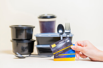 Food Products Order Online Delivery Concept - Hands holding Three credit card and Background blur Restaurant healthy food delivery in take away boxes.