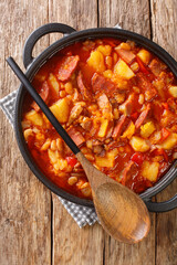 Locro is a thick and nourishing stew which originated in South America close-up in a pot on the table. vertical top view from above