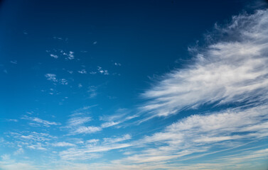 Naklejka na ściany i meble frayed cirrus clouds on deep blue sky