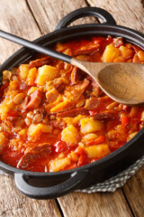 Locro is a thick and nourishing stew which originated in South America close-up in a pot. vertical