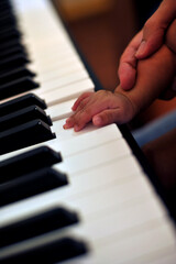 Hand Little son to play the piano, kid on piano keyboard - Image