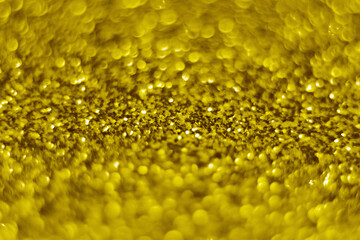 Glitter splash and lens flare on gold shiny trendy background. Sequins. Festive background for your projects. Blurred golden festive bokeh lights. Christmas festive time concept on background.