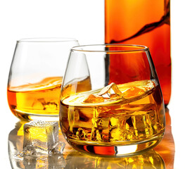 Glasses of whisky and ice on a white background