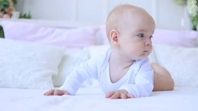 a child plays with a rattle on the bed at home