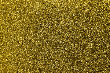Glitter splash and lens flare on gold shiny trendy background. Sequins. Festive background for your projects. Blurred golden festive bokeh lights. Christmas festive time concept on background.