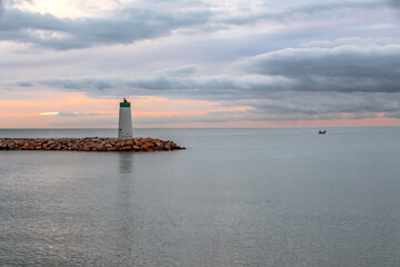 Fototapeta premium Lever de soleil sur la mer près du phare du port de Villeneuve Loubet sur la Côte d'Azur