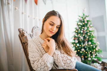young girl in beige sweater on christmas background