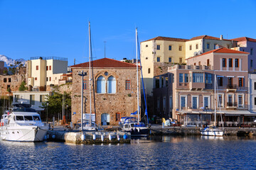 Sailing boats anchored by piers of Old Venetian harbour and Grand Arsenal, Venetian shipyard, in Chania, Crete, Greece.